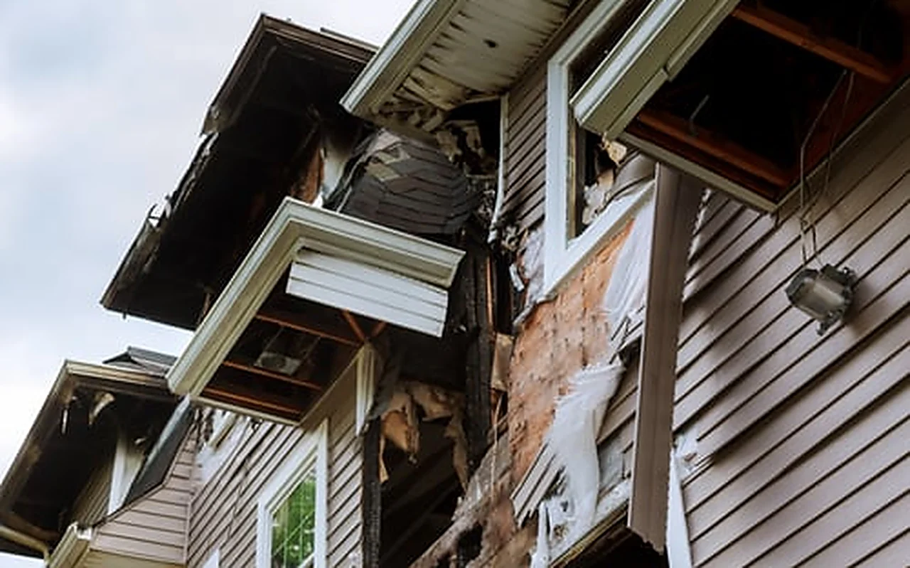 Damaged and deteriorating exterior siding and soffit on a weather-worn home