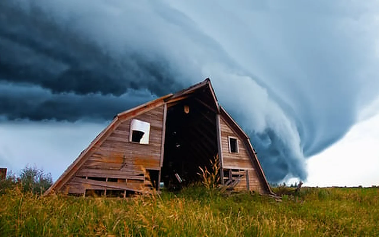 Dramatic shelf cloud from a severe thunderstorm rolling over a barn in rural Nebraska