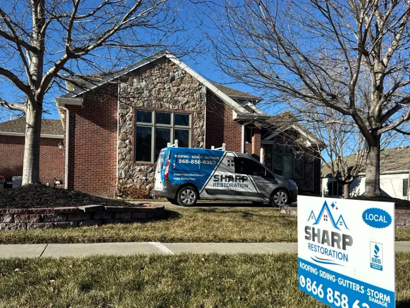 Sharp Restoration van and yard sign outside a Nebraska home during a roof replacement