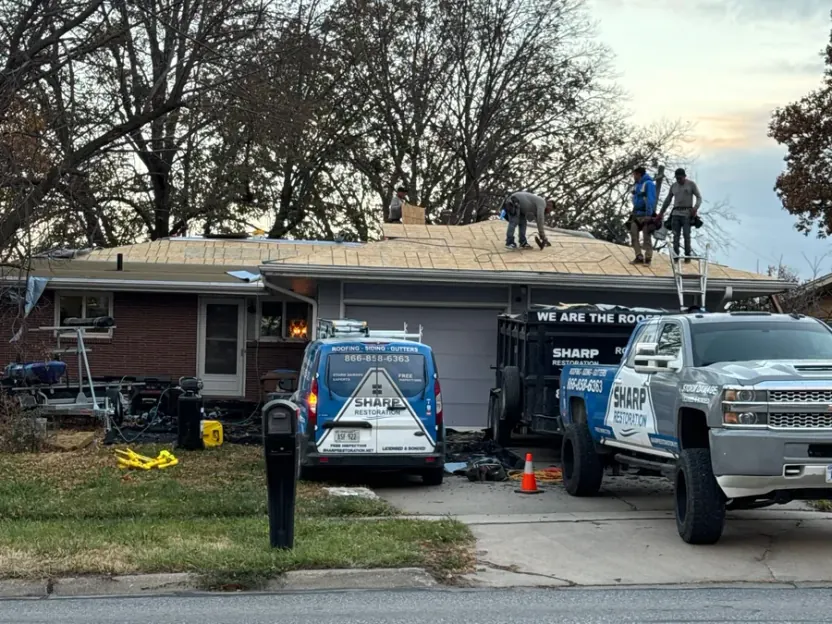 Sharp Restoration crew and trucks during a full residential roof replacement