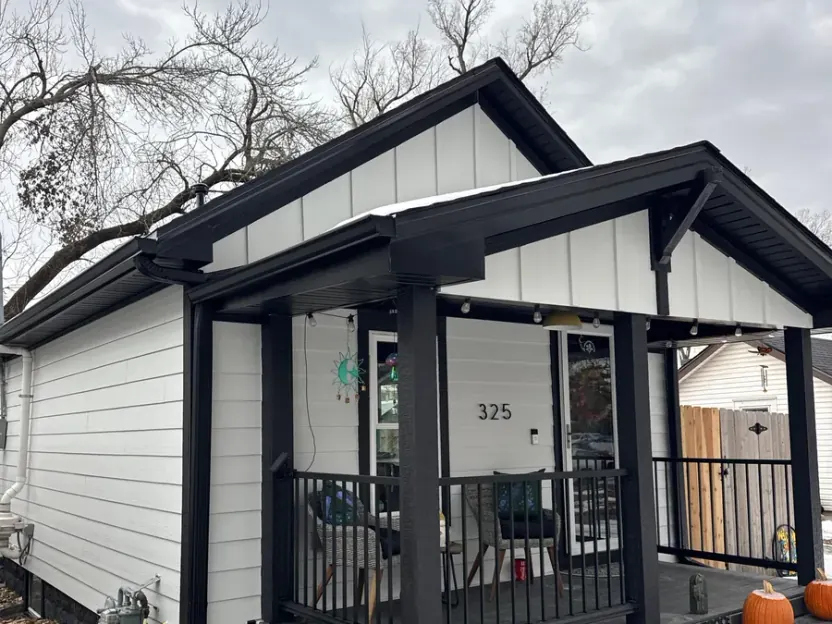 Completed white board-and-batten siding and black porch trim on a Nebraska home