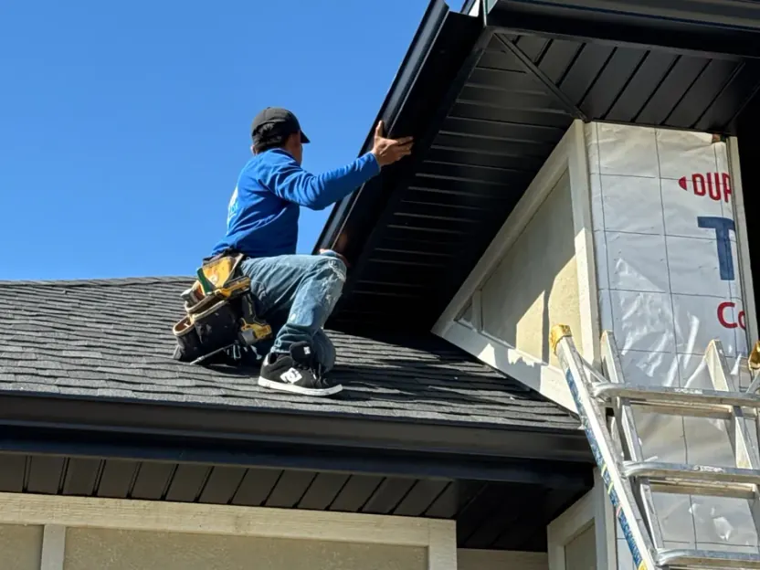 Technician installing new seamless gutter and fascia on a Nebraska roofline